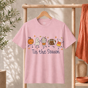 Cute Halloween Pumpkin Ghost Football Coffee Candy Corn Shirt on a pink t-shirt with playful graphics and text 'Tis the Season.