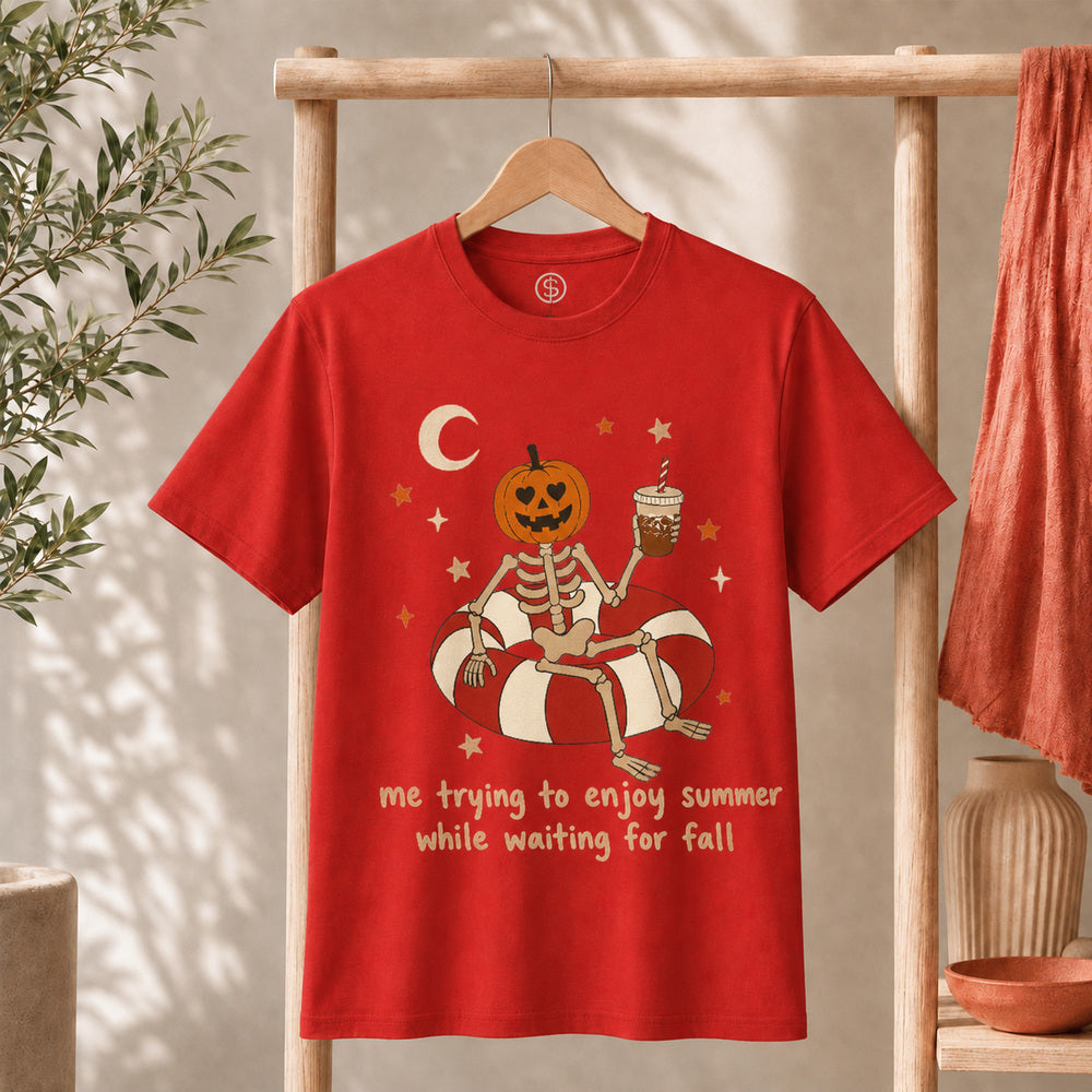 Me Trying to Enjoy Summer While Waiting for Fall Tee featuring a skeleton with a jack-o'-lantern head on a pool float.