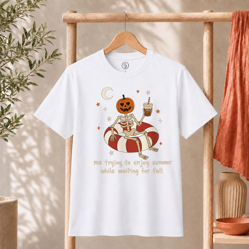 Me Trying to Enjoy Summer While Waiting for Fall Tee featuring a skeleton with a jack-o'-lantern head on a pool float.