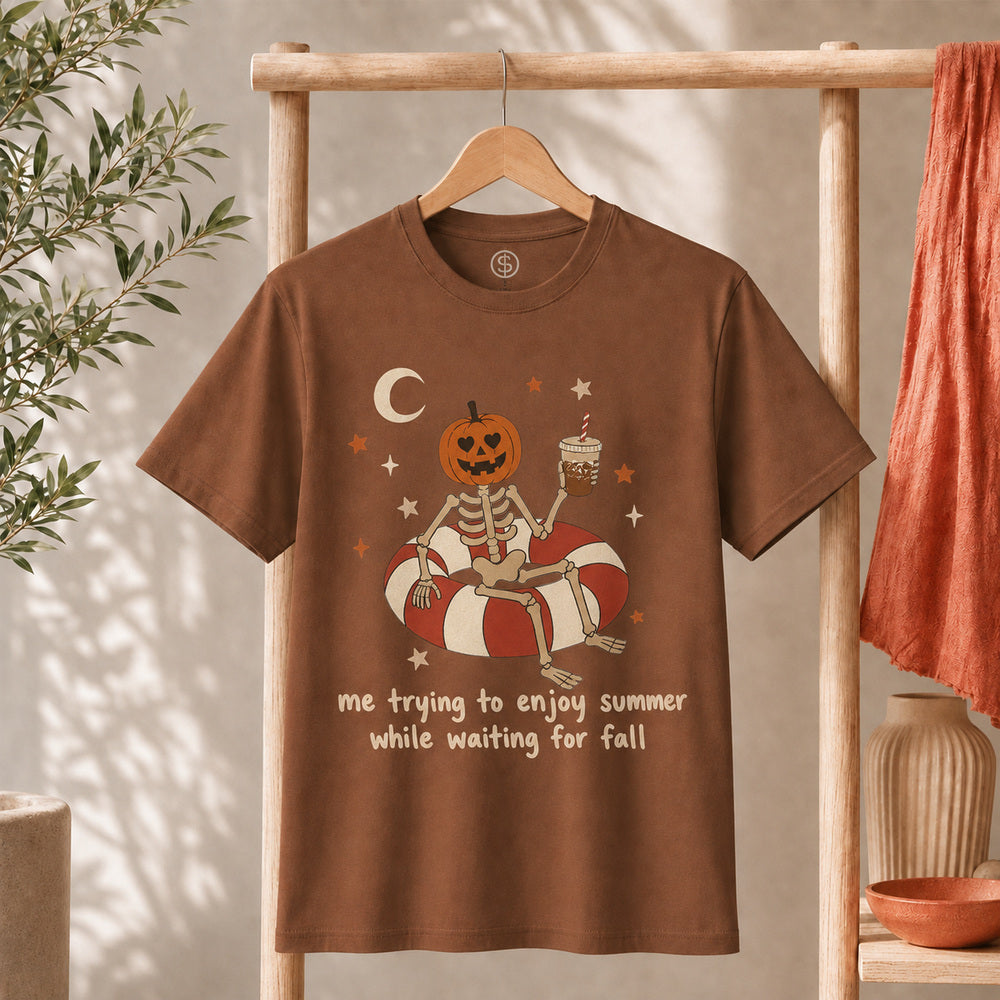 Me Trying to Enjoy Summer While Waiting for Fall Tee featuring a skeleton and jack-o'-lantern on a float.