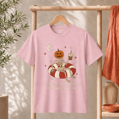 Me Trying to Enjoy Summer While Waiting for Fall Tee featuring a skeleton with a jack-o'-lantern head on a float.