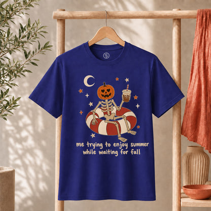 Me Trying to Enjoy Summer While Waiting for Fall Tee featuring a skeleton with a jack-o'-lantern head on a float.