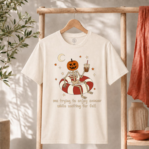 Me Trying to Enjoy Summer While Waiting for Fall Tee featuring a skeleton with a pumpkin head on a pool float.
