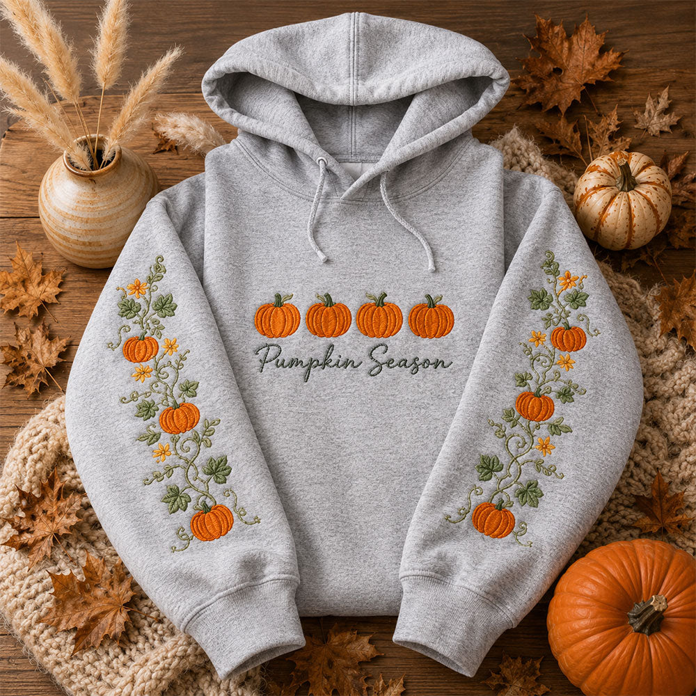 Pumpkin Season Embroidered Hoodie featuring pumpkin designs and autumn leaves on a cozy gray background.